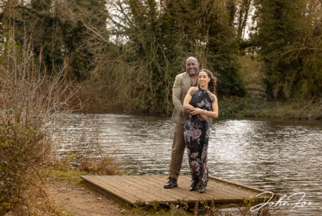 A Relaxed Pre-Wedding Session in Buckinghamshire for Figan and Philip as they hold each other while next to a parkland lake.