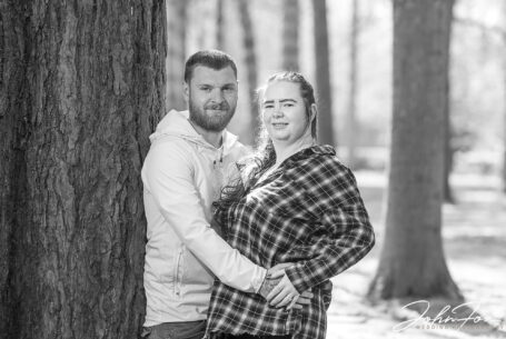 Pre-wedding shoot at the Tree Cathedral in Milton Keynes, Buckinghamshire - Jade and Lewis leaning against a tree