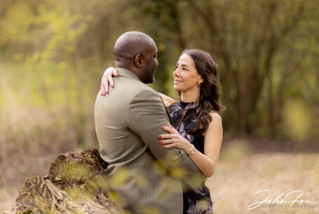 Pre-wedding shoot in parkland in Milton Keynes, Buckinghamshire. Figan with her arms around Philip.