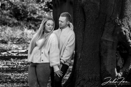 Pre-wedding shoot at Mapperley Reservoir's woodland area with the happy couple leaning against a tree. John Fox: wedding photographer covering Nottinghamshire