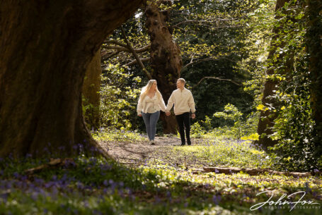Pre-wedding shoot at Mapperley Reservoir's woodland area with the happy couple walking through the woodland with a huge oak framing the scene. John Fox: wedding photographer covering Nottinghamshire