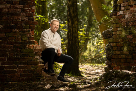 Pre-wedding shoot at Mapperley Reservoir's woodland area with the groom-to-be, Kieran, sat on brickwork. John Fox: wedding photographer covering Nottinghamshire